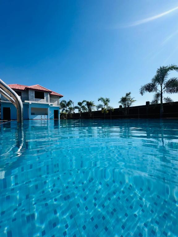 a large swimming pool with blue water at Alpine Resort in Sibsāgar