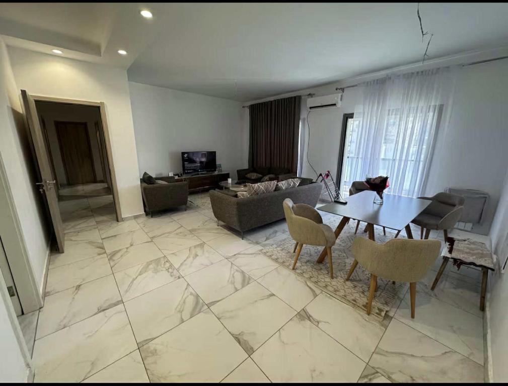 a living room with a table and a couch at Grand appartement 3 chambres à la résidence valmascort Annaba in Annaba