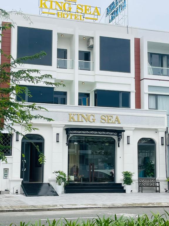 Thôn Vĩnh ThanhKing Sea Hotel的一座白色建筑，上面有萨哈国王的标志