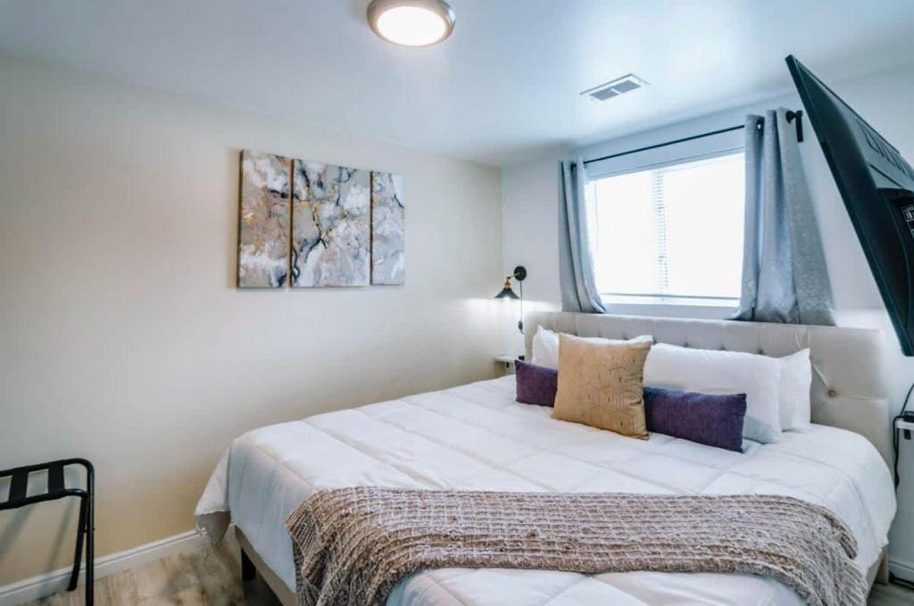盐湖城Exclusive Downtown SLC Spot, King Bed 2 Bed 1 Bath的卧室里有一张白色的大床和一扇窗户