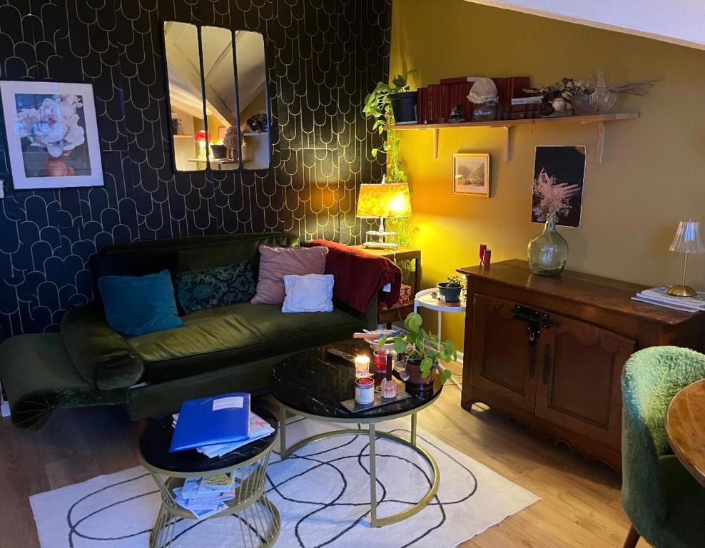 uma sala de estar com um sofá e uma mesa em Élégant appartement Mer & Golf em Ciboure