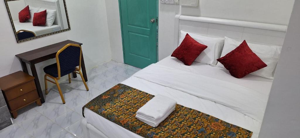 a bedroom with a bed with red pillows and a desk at Sofea Rania Homestay in Kota Belud