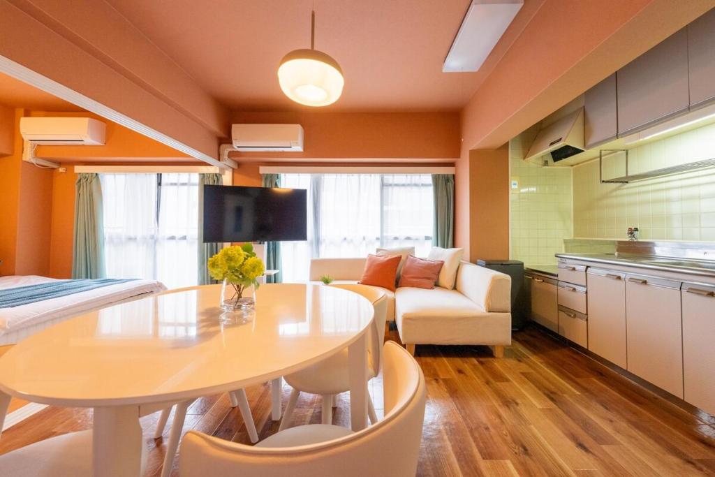 綺麗に改装されたアパートメント 京都や新大阪駅へアクセス良好 3ベッド 1バスルーム في أوساكا: مطبخ وغرفة معيشة مع طاولة وأريكة