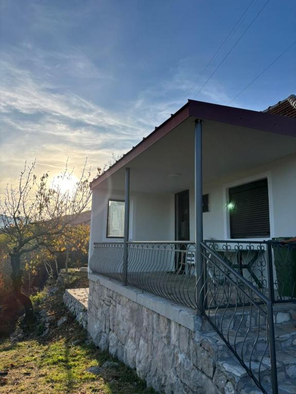 a house with a balcony with the sunset in the background at Lakeside View in Kuside