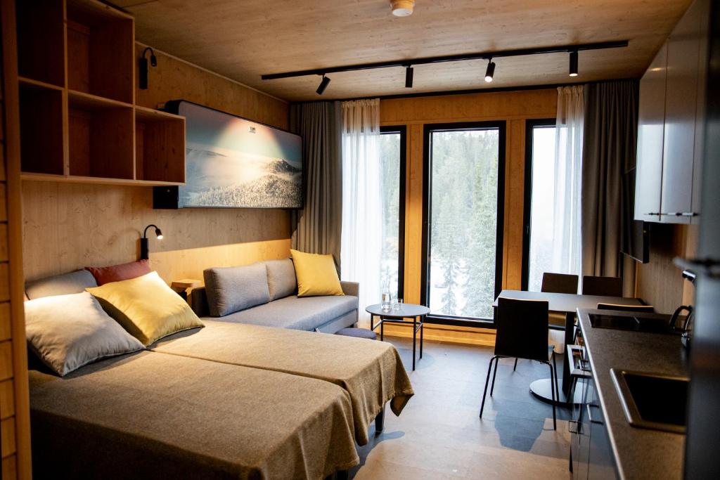 a bedroom with a bed and a desk and a couch at Ski-inn Parkside in Ruka