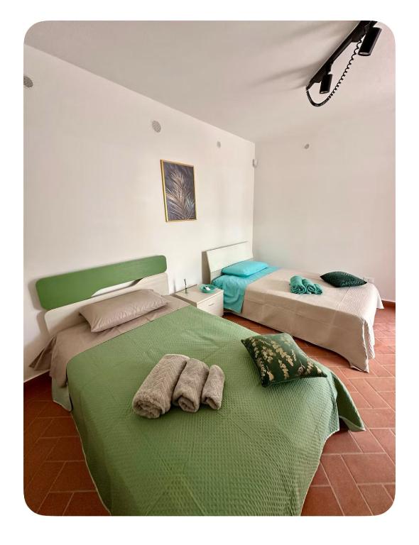 Un dormitorio con dos camas con toallas encima. en Borgo Vesuviano, en San Sebastiano al Vesuvio