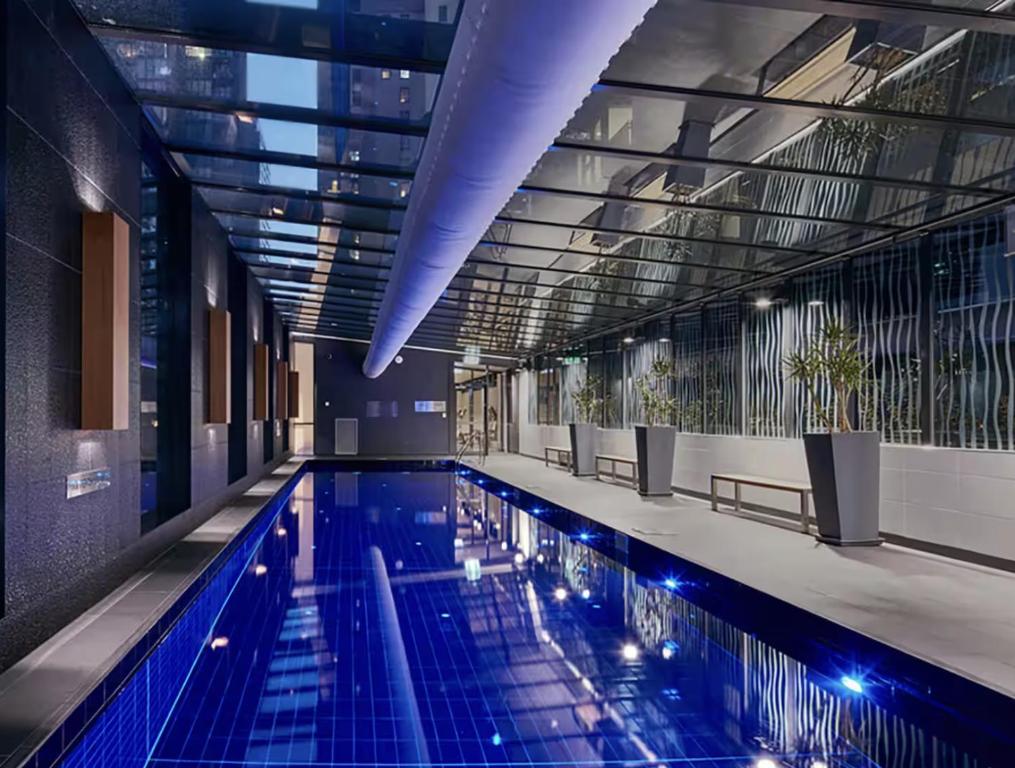 a large swimming pool in a building at Balcony, Free Parking, Workspace, Shared Pool & Gym in Melbourne