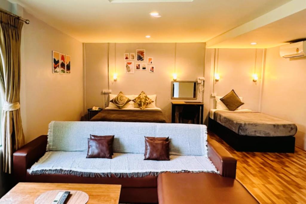 a living room with a couch and a bed at Viphuanan Resort in Nong Prue