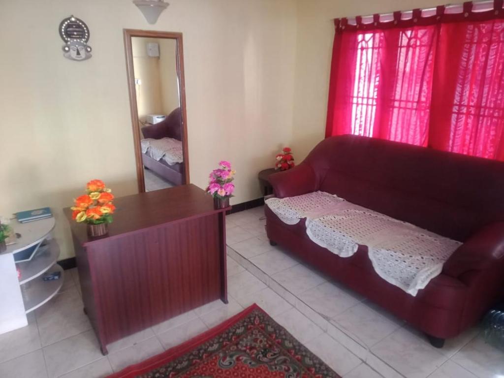 uma sala de estar com um sofá e um espelho em Sunshine Royale em Kodaikānāl