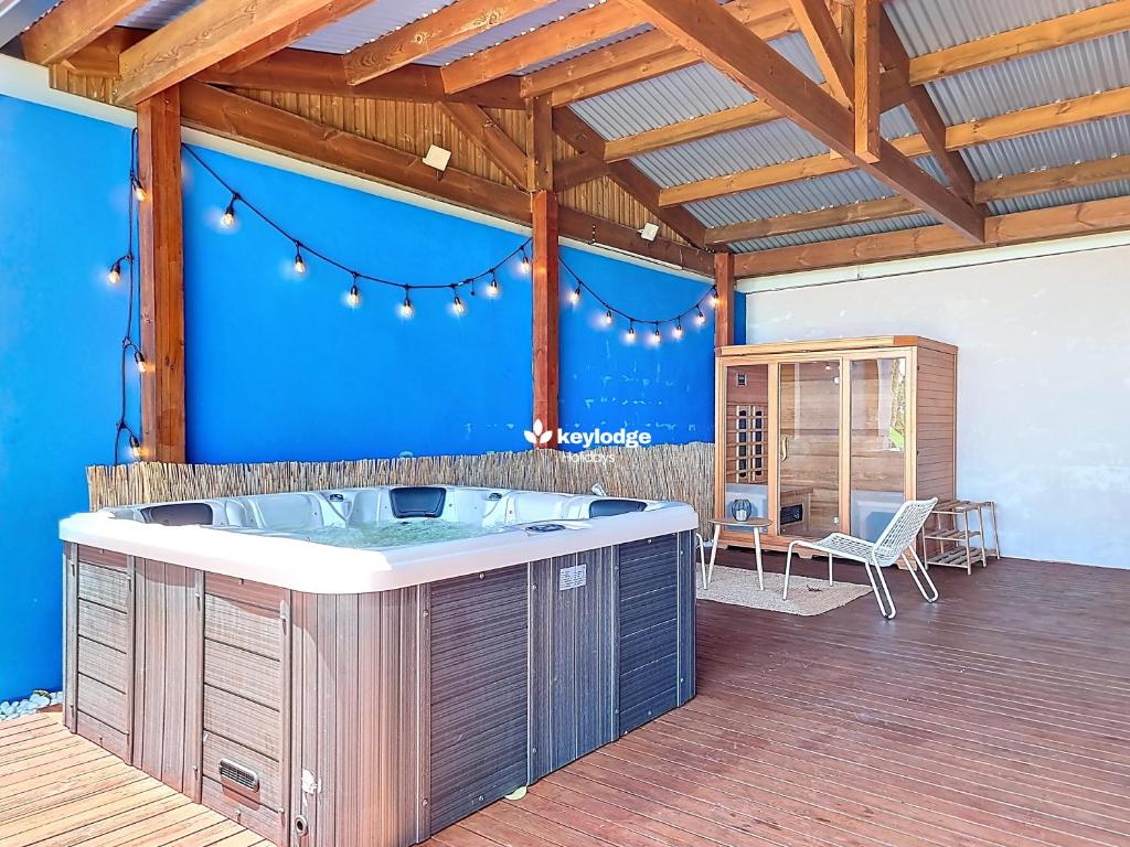 een hot tub in een kamer met een blauwe muur bij Bleu des Ô - Maison de 66m2 avec jacuzzi et sauna in Sainte-Marie