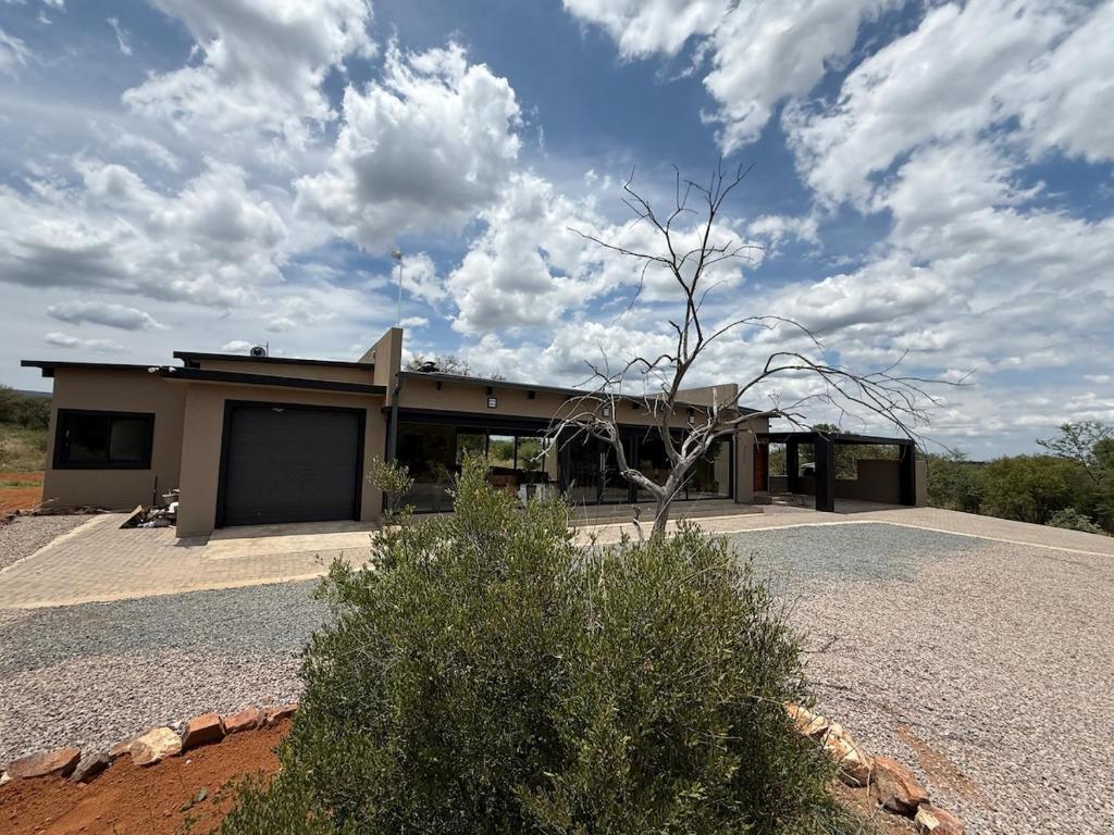 a house in the middle of a field at Blessed Lodge at Ingilozi Mabalingwe in Warmbaths