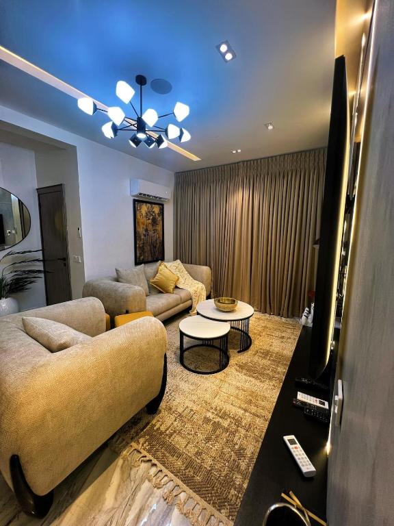 a living room with two couches and a tv at Urban Muse in Lekki