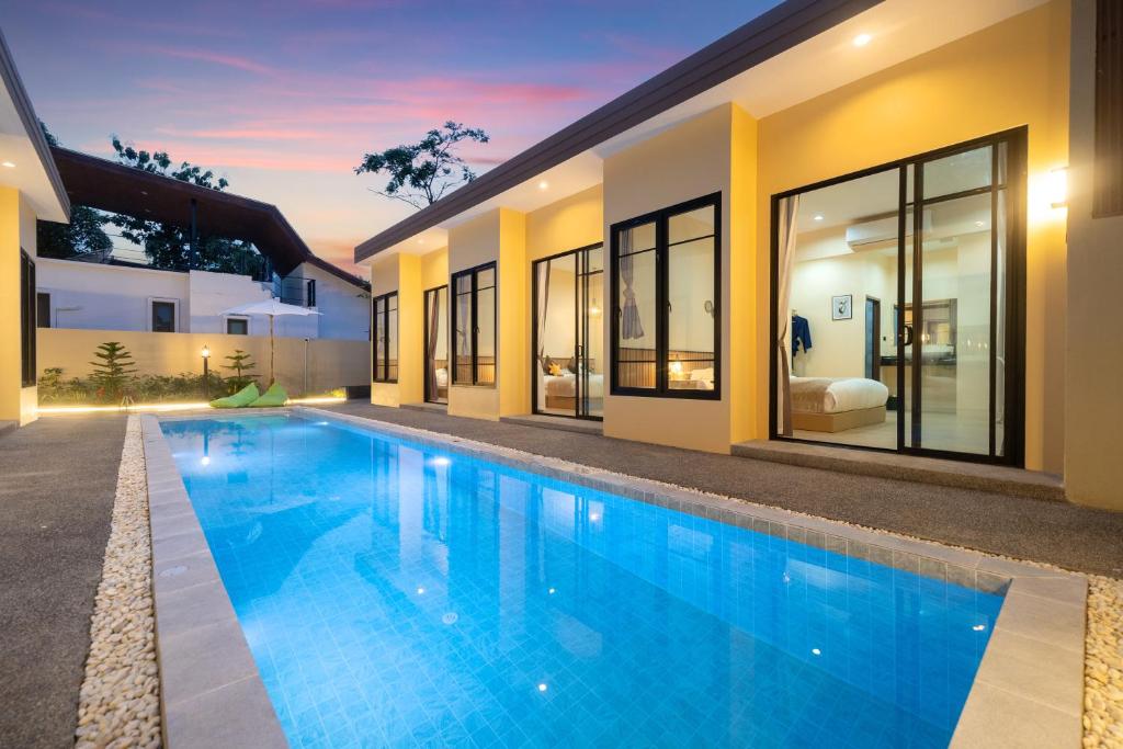 a swimming pool in the backyard of a house at Amaleena Pool Access Suites in Ban Bang Chak