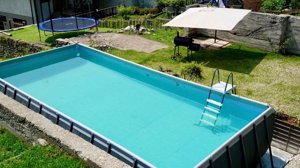 une piscine vide avec une chaise et un parasol dans l'établissement Apartment Gisa with private pool at 50 m, à Colazza