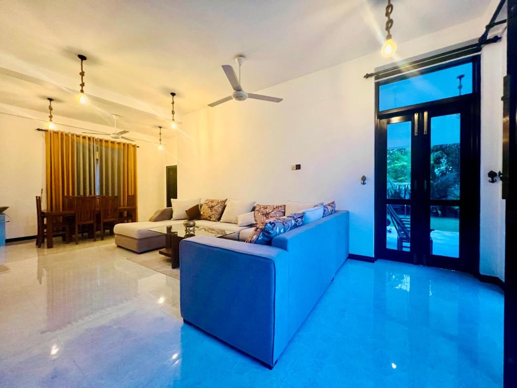 ディックウェラにあるMeadow View Villaのソファと天井ファンのあるリビングルーム