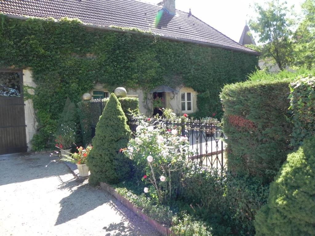 a house with a garden with flowers and a fence at Les Belins in Bourg-le-Comte