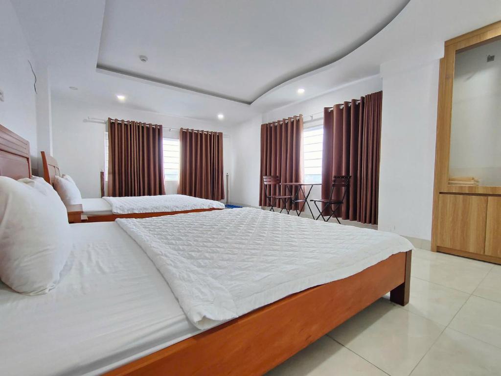 ein großes Schlafzimmer mit einem großen Bett mit weißer Bettwäsche in der Unterkunft Khách sạn Hiệp Thạnh in Buon Ma Thuot