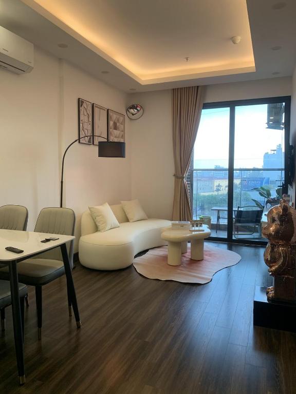 a living room with a white couch and a table at X-Stay Sweet in An Khê
