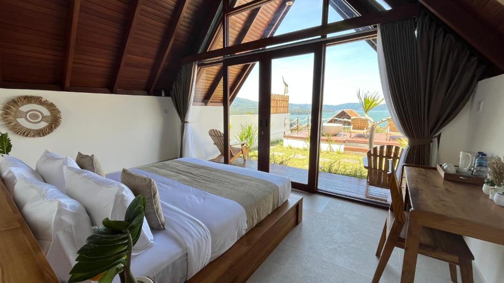 Un dormitorio con una cama y un escritorio y una gran ventana. en Kedisan Panorama, en Kubupenlokan