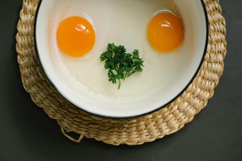 Blue Sky Hotel Clifton 2 في كراتشي: بيضتان على طبق مع البقدونس في الأعلى