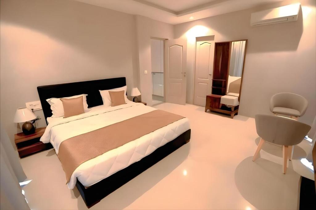 Un dormitorio con una cama grande y una silla. en Rio Colina - D Diamond 3BHK Villa in Surat, en Dighas