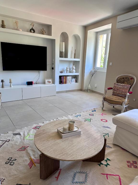 ein Wohnzimmer mit einem Couchtisch und einem Flachbild-TV in der Unterkunft Agréable maison de ville avec terrasse et garage in Saint-Affrique
