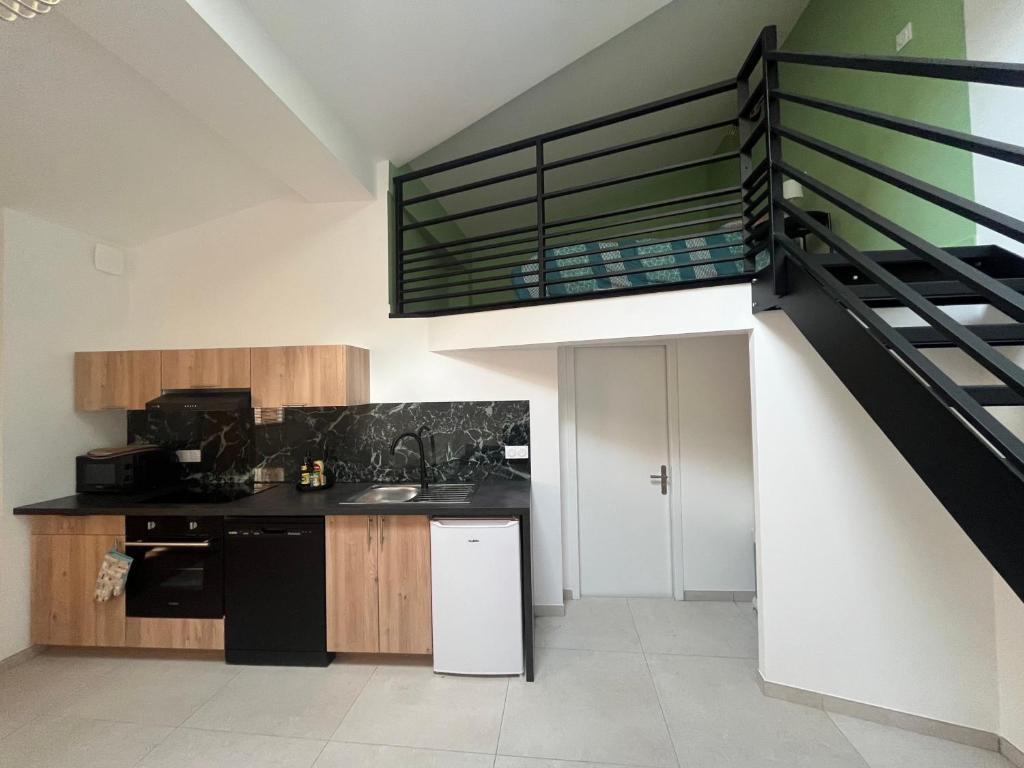 une cuisine avec un évier et un escalier dans l'établissement La Vie est Belle, à Saint-Symphorien-sur-Coise