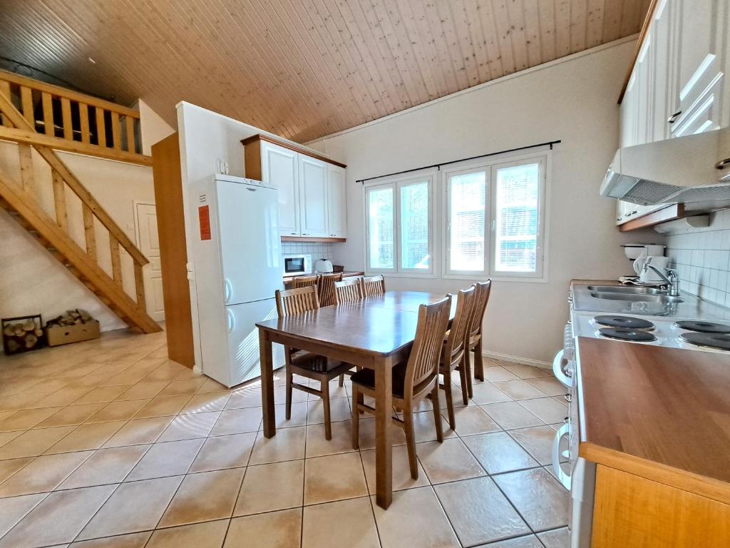 a kitchen with a table and chairs in a room at Aamuaurinko in Korospohja