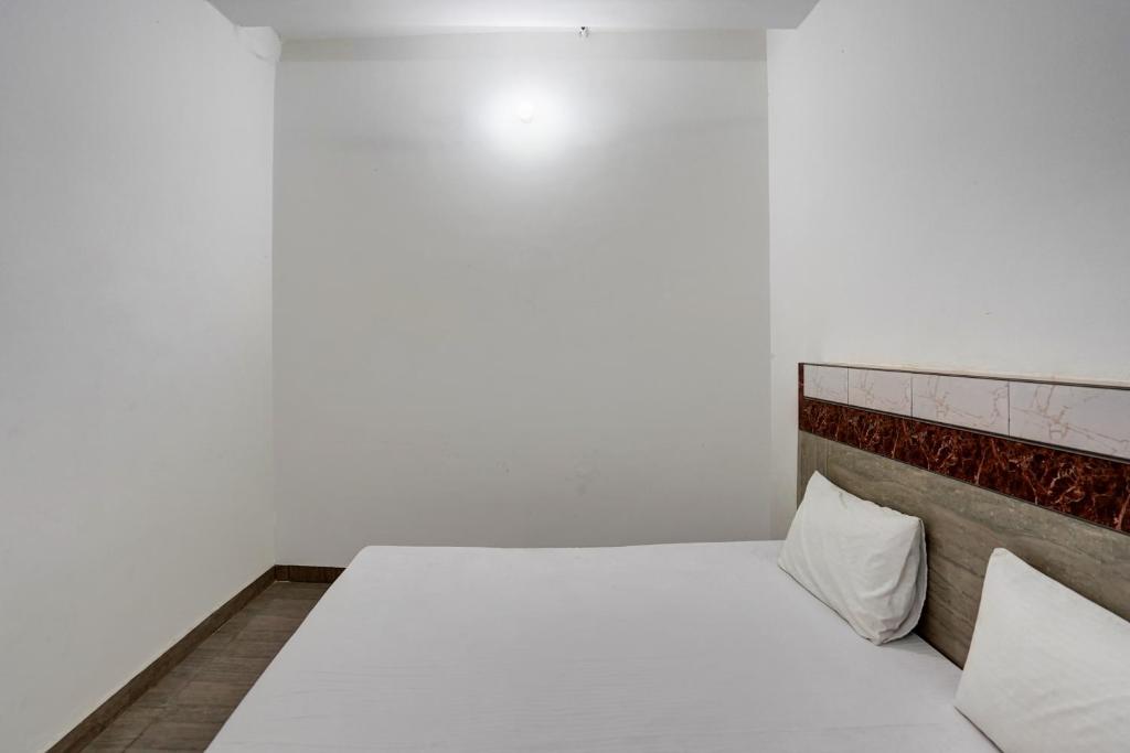 加济阿巴德Spot On Sky Line的卧室里有一张白色的床，上面有两个枕头