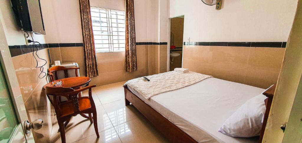 ein kleines Schlafzimmer mit einem Bett und einem Stuhl in der Unterkunft Motel Bờ Kè in Bà Rịa