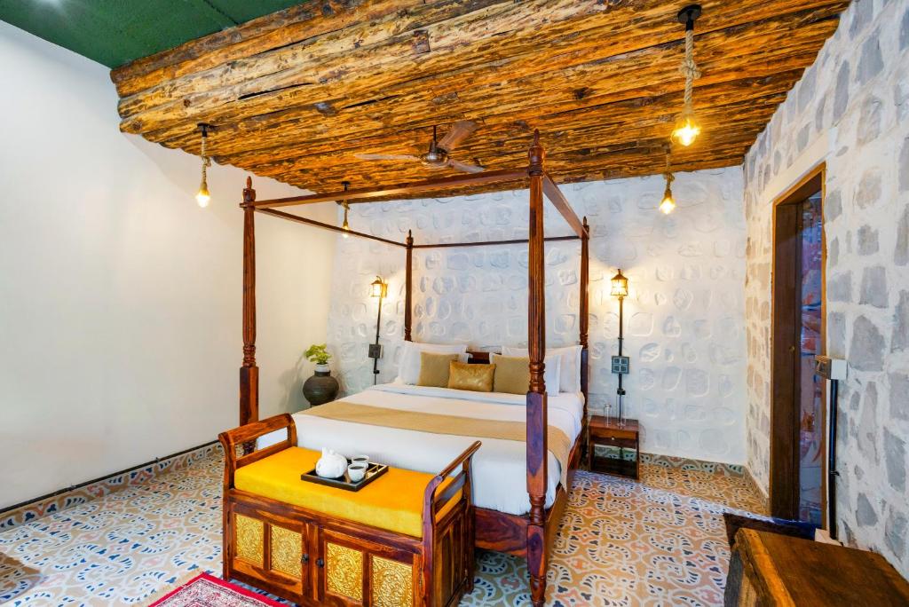 a bedroom with a bed and a wooden ceiling at Granny's Den BY ELIVAAS in Dhanaulti