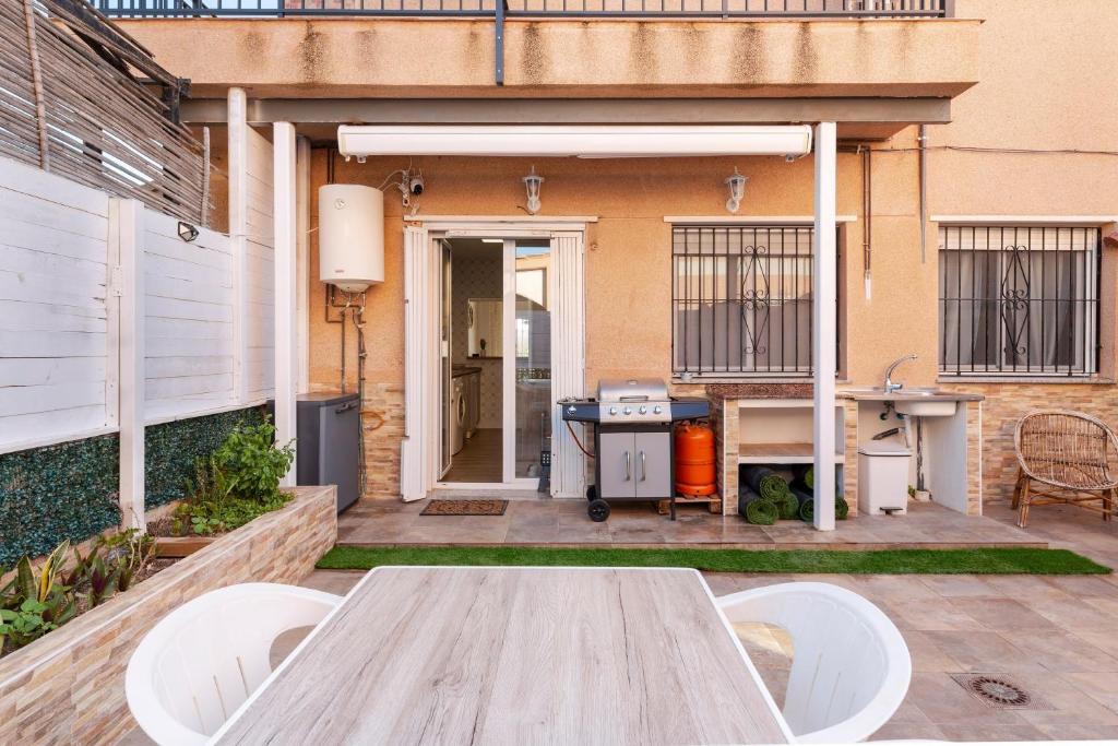a patio with a table and chairs in front of a building at La historia de la Casa de los Gatos in Los Narejos
