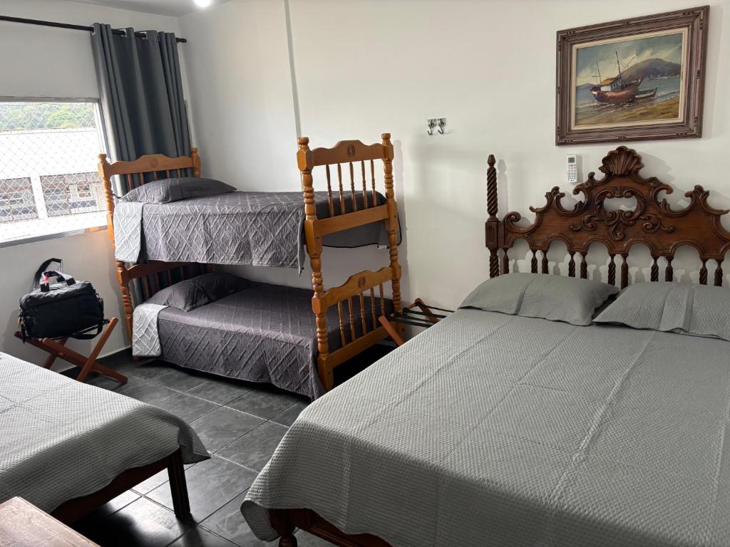 ein Schlafzimmer mit zwei Betten und einem Stuhl in der Unterkunft Apartamento espaçoso com vista deslumbrante in São Vicente