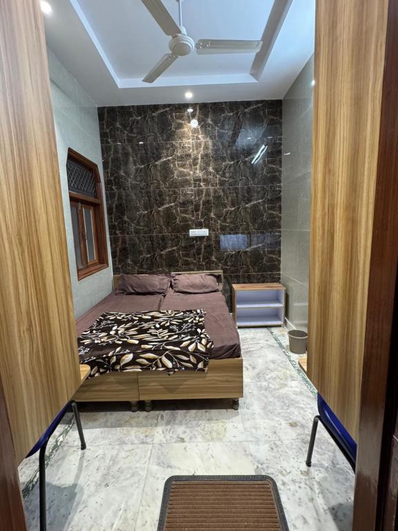 a bedroom with a bed and a stone wall at FlexiBay-Affordable Hostel in North Delhi in Delhi