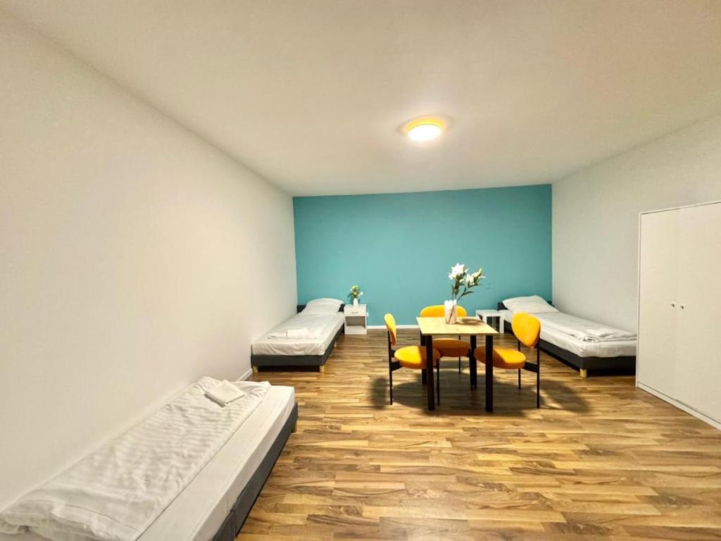 a room with two beds and a table and chairs at Casa Heusenstamm in Heusenstamm