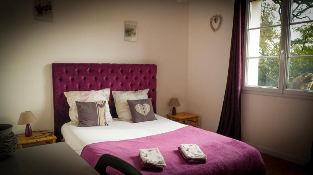 a bedroom with a large bed with a purple blanket at Chambre d'hôtes Sous Les Grands Chênes LOVE in Saint-Étienne-de-Corcoué