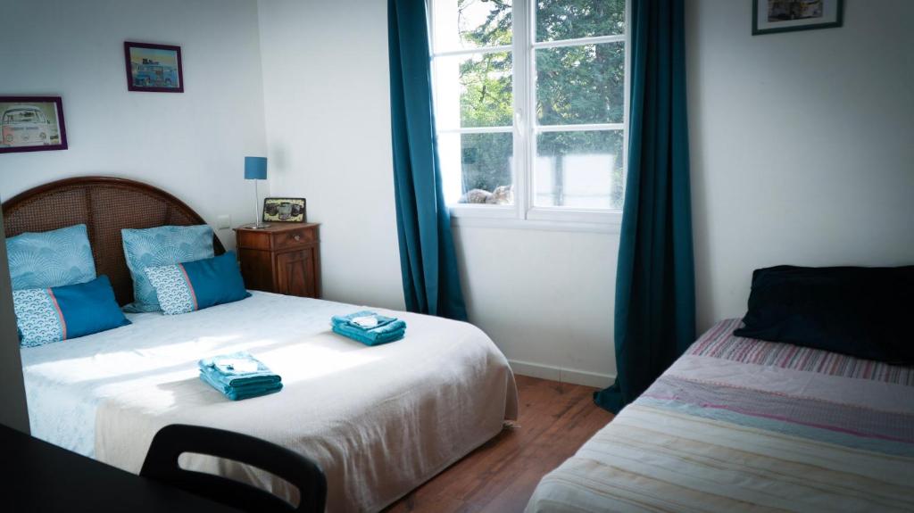 a bedroom with two beds with blue boxes on them at Chambre d'hôtes Sous Les Grands Chênes BOHEME in Saint-Étienne-de-Corcoué