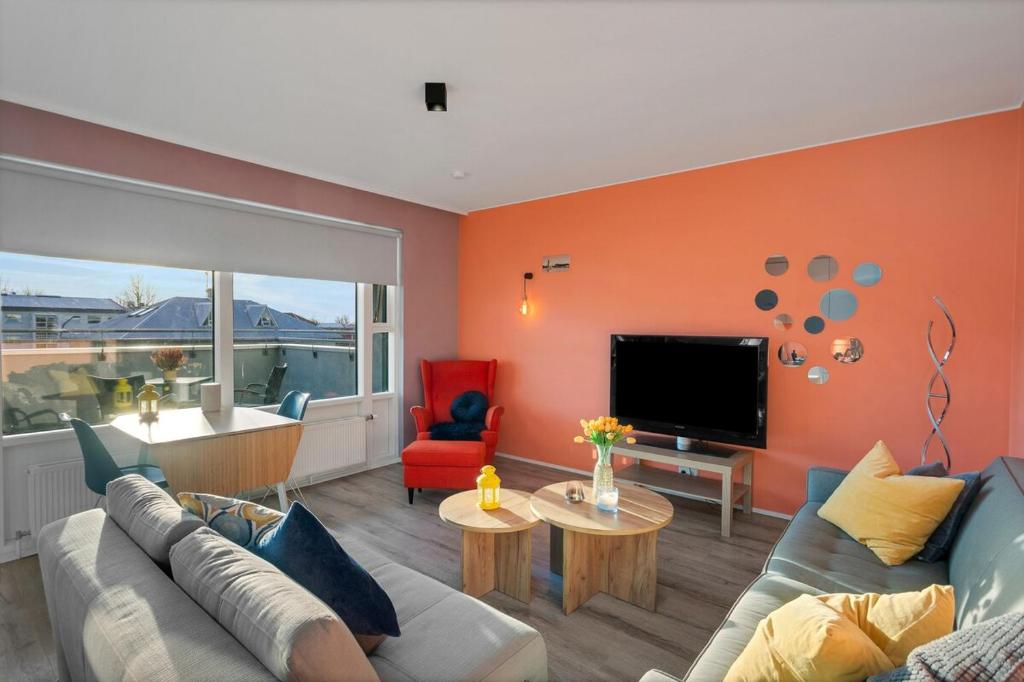 a living room with a couch and a tv at Bright and Spacious Condo Downtown in Reykjavík