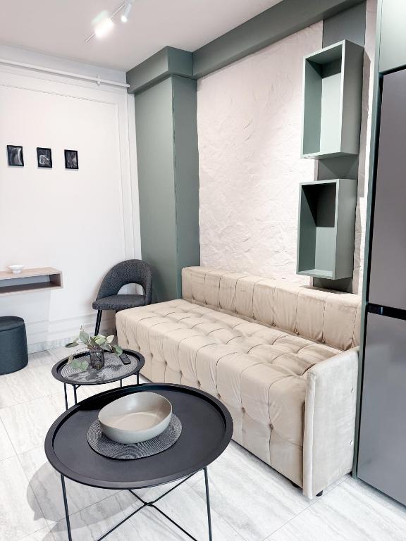 un salon avec un canapé et deux tables dans l'établissement Sky Escape - Private Parking, Kingsize Bed, à Someşeni