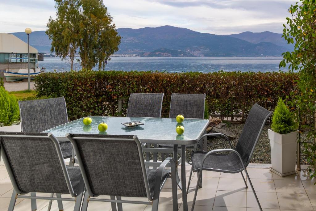 a table and chairs with a view of the water at Placebo Apartment in Kritharia
