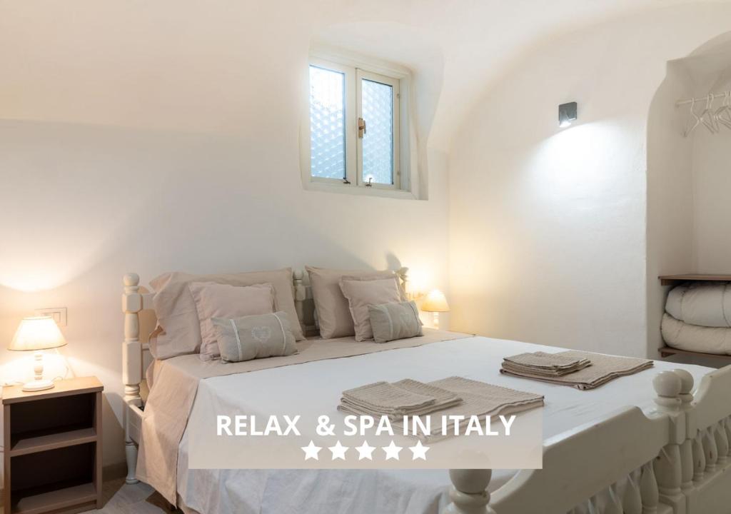 ein weißes Schlafzimmer mit einem Bett und einem Fenster in der Unterkunft VACANZE VICINO ALLE PISTE - Vicino a Parcheggio e Centro Benessere - Parco Naturale Adamello Brenta - WI-FI & Netflix in Caderzone