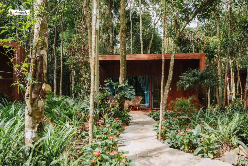 une maison dans les bois avec un chemin traversant un jardin dans l'établissement Rung Thong Nui Voi Villa & Resort, à Ðưc Trọng