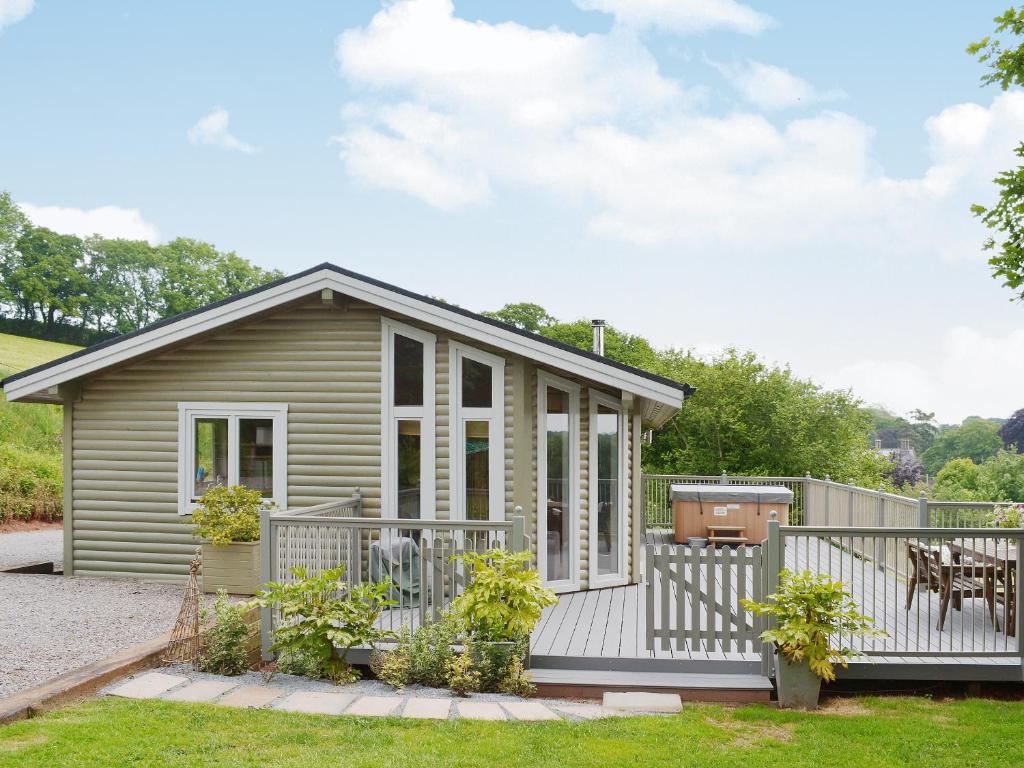 ein kleines Haus mit einer Veranda und einer Terrasse in der Unterkunft Wattles-E4527 in Uplowman