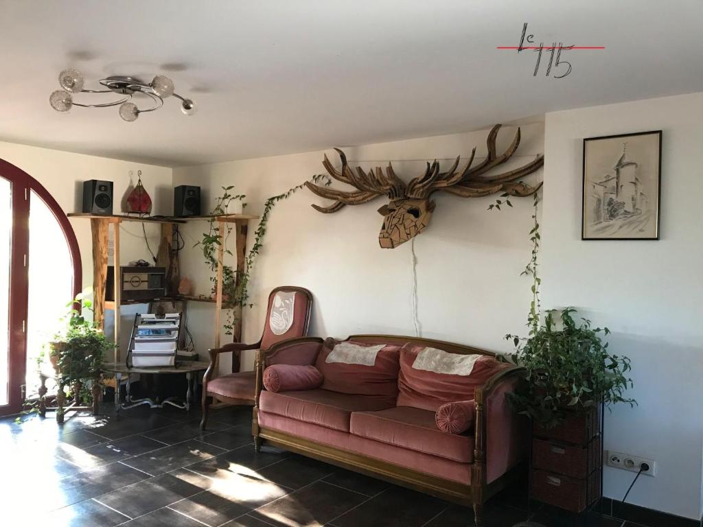 - un salon avec un canapé et des bois sur le mur dans l'établissement Le 115 Retour aux Sources, à Dounoux