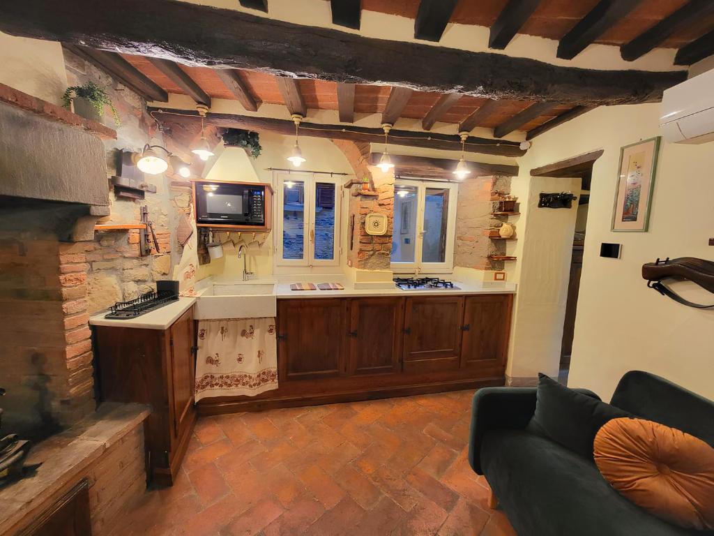ein Wohnzimmer mit Küche mit Couch in der Unterkunft Casa della Rosa in Cortona