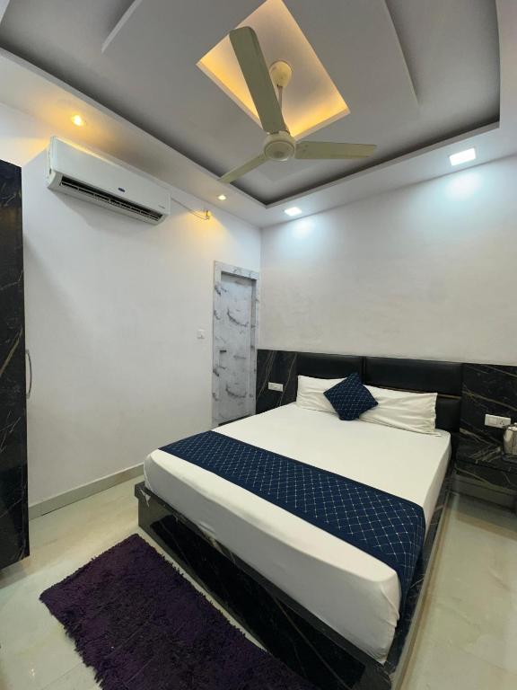 a bedroom with a bed and a ceiling fan at Hotel Peepal Tree Prayagraj in Prayagraj