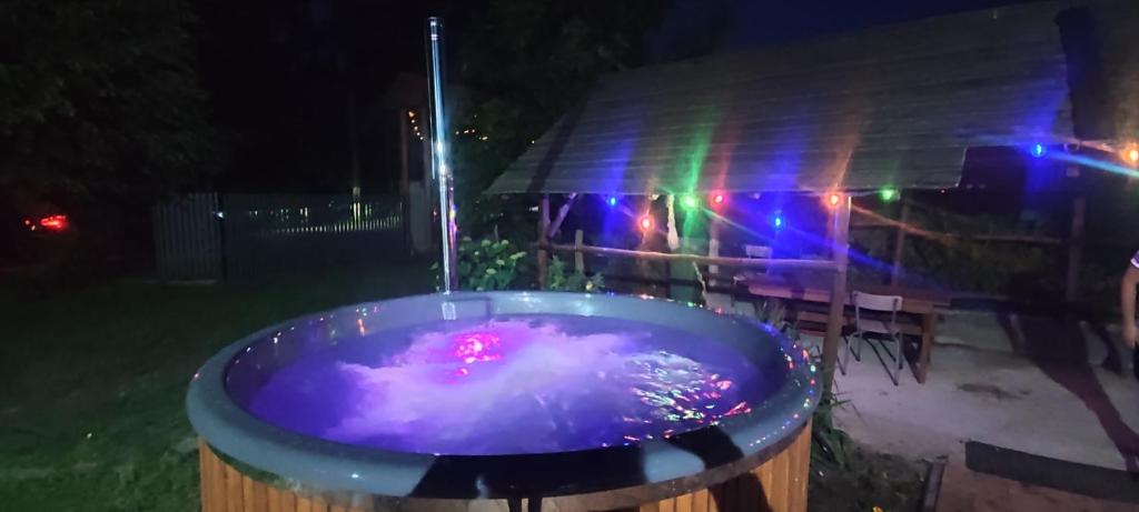 a hot tub in a yard at night with lights at Agrowczasy Nad Stawem - Plus strefa jacuzzi przy domu z jedną sypialnią in Gartatowice