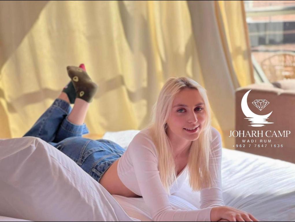 Eine junge Frau auf einem Bett mit erhobenen Füßen. in der Unterkunft BUBBlES JOHRH LUXURY CAMP in Disah