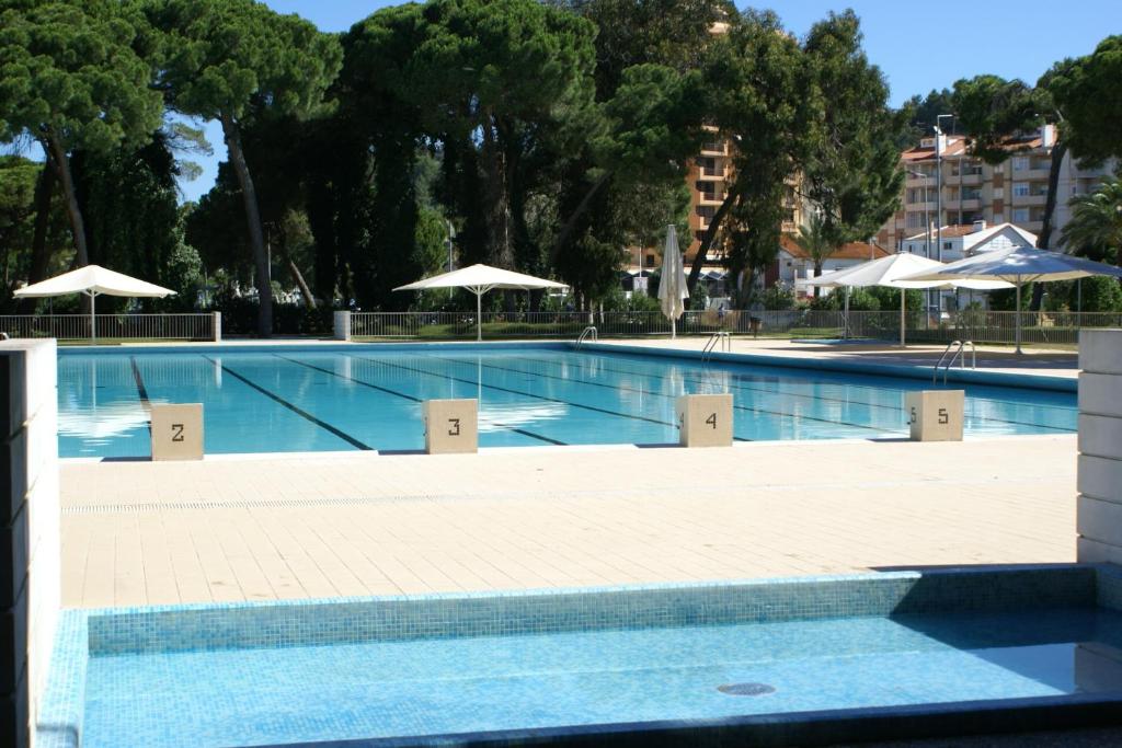 a large swimming pool with umbrellas in a building at INATEL Caparica in Costa da Caparica