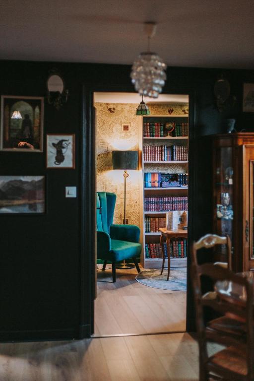 a living room with a green chair and a table at Le gîte du Sorcier 89 in Avallon